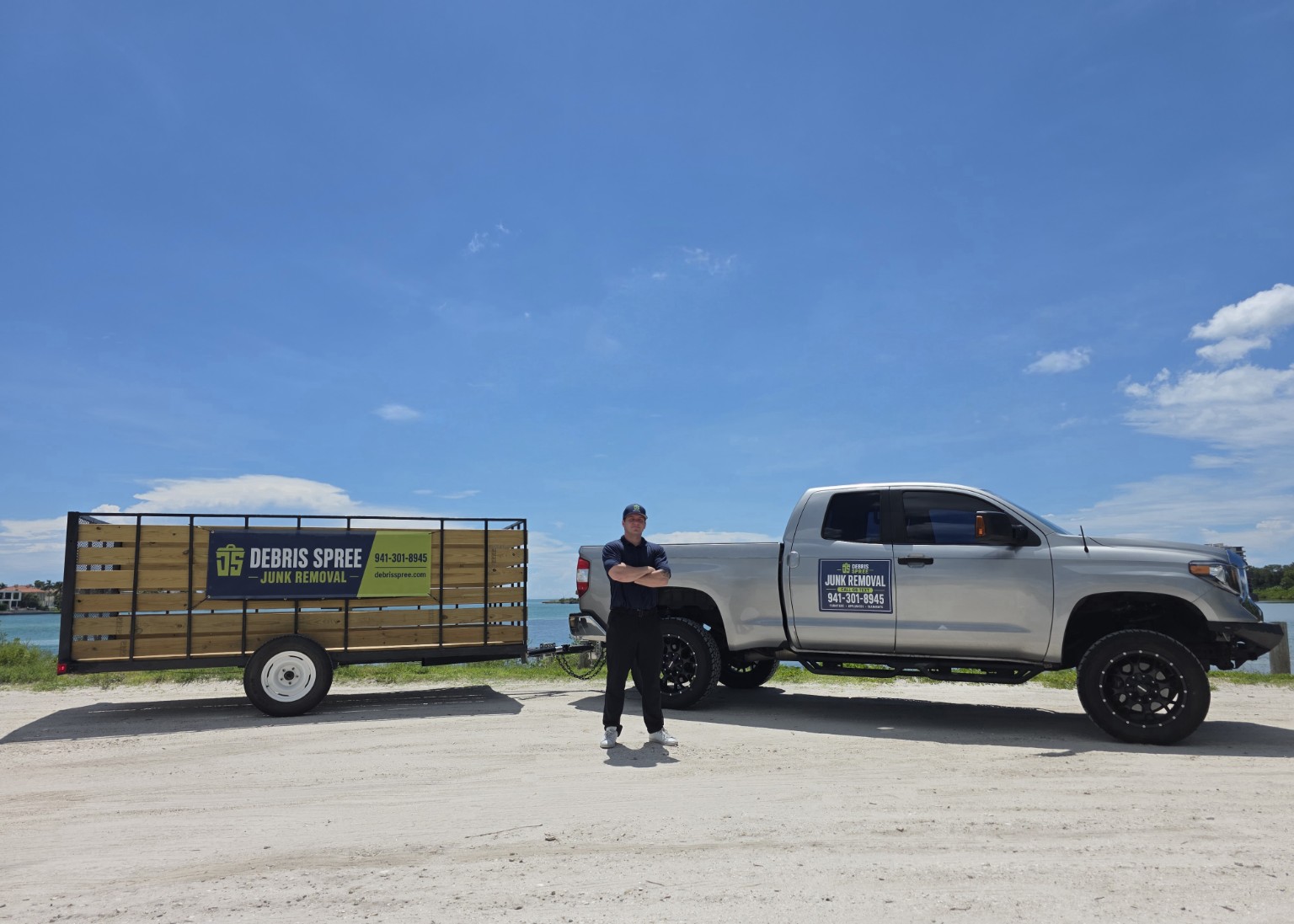 Caleb standing with the Debris Spree truck and junk removal trailer